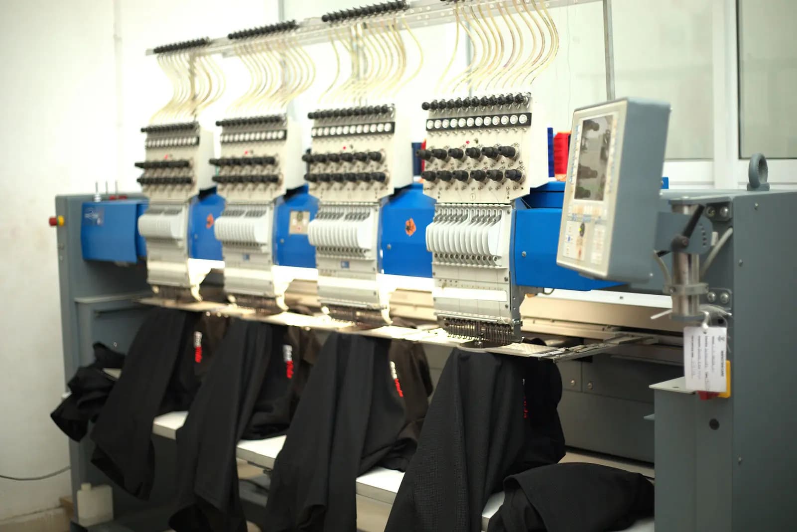 Multi-head embroidery machines running a production batch